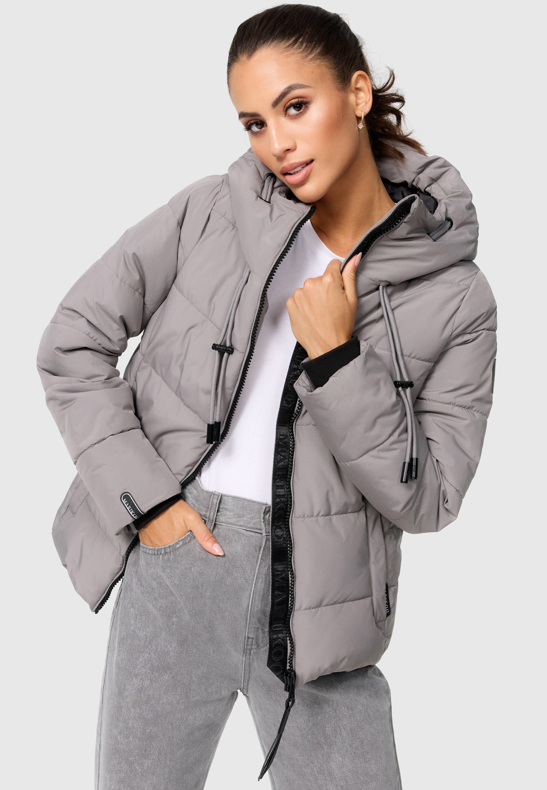 Die Marikoo Steppjacke "Shimoaa" ist eine leicht taillierte Pufferjacke mit breiter Steppung, kontrastfarbenen Details und verstellbarer Kapuze.